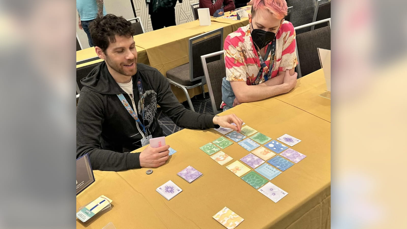 People playing a prototype version of the card game Threed at Unpub.