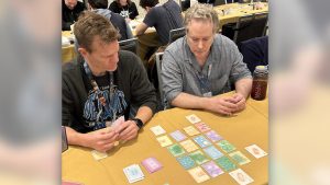 People playing a prototype version of the card game Threed at Unpub.