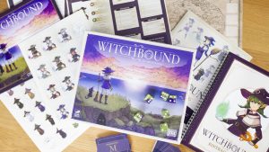 Witchbound board game box and components featuring illustrated witches, character cards, a game map, and dice on a wooden table.