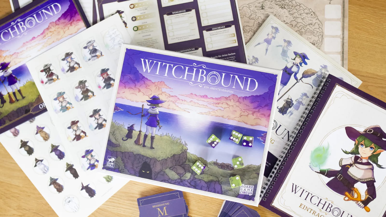 Witchbound board game box and components featuring illustrated witches, character cards, a game map, and dice on a wooden table.